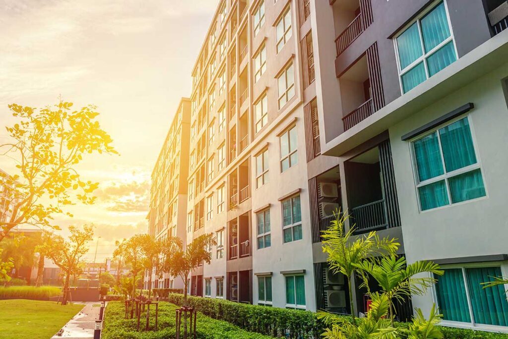 sun setting next to a residential building